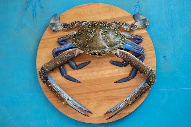 Crabe bleu sur une planche à découper en bois