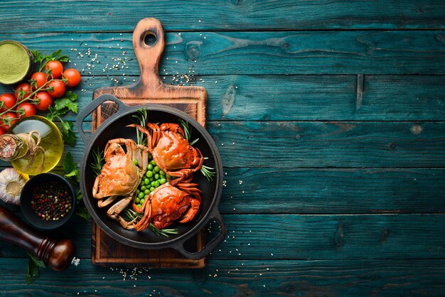 Crabes de mer bouillis avec des légumes dans une poêle noire Fruits de mer Vue de dessus Espace libre pour votre texte