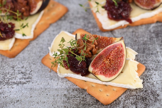 Cracker avec une tranche de confiture de camembert figues et noix Une excellente idée de collation pour les vacances