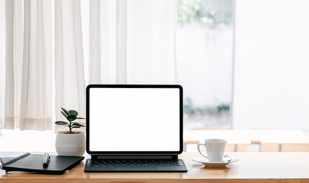 Écran blanc talet avec clavier sur table en bois dans un salon moderne.