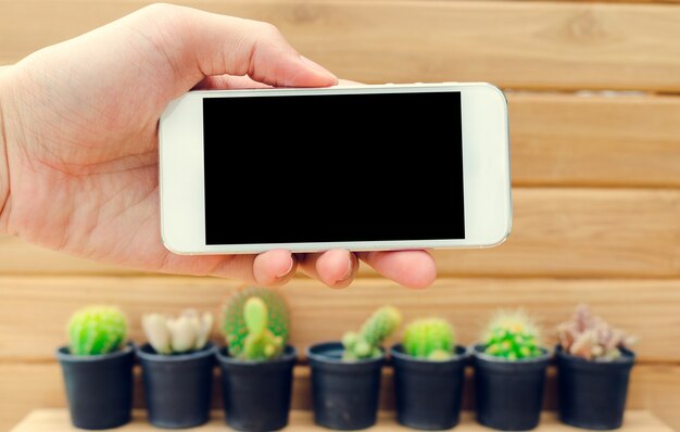 Écran blanc de téléphone portable sur fond de bois