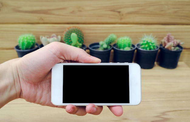 Écran blanc de téléphone portable sur fond de bois