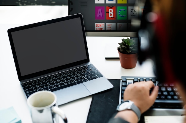 Écran d&#39;ordinateur portable montrant un bureau noir sur la table à côté de l&#39;homme au travail