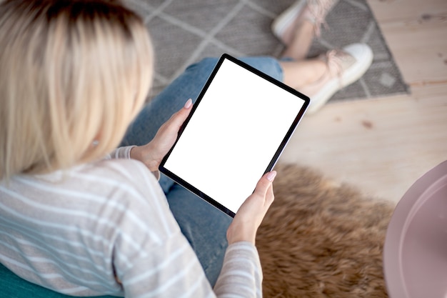 Écran de tablette entre les mains d'une femme utilisant une tablette numérique