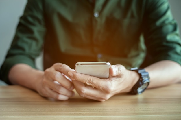 Écran tactile de main d'homme d'affaires de plan rapproché sur le téléphone intelligent