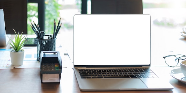 Écran vide d'ordinateur portable avec machine EDC sur une table dans un café