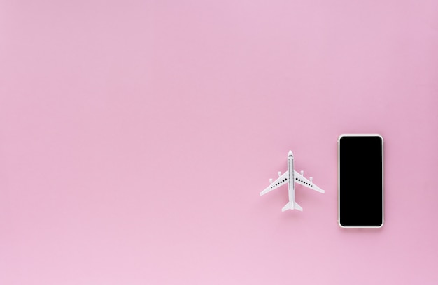 Écran vide de smartphone avec modèle d'avion blanc sur fond rose