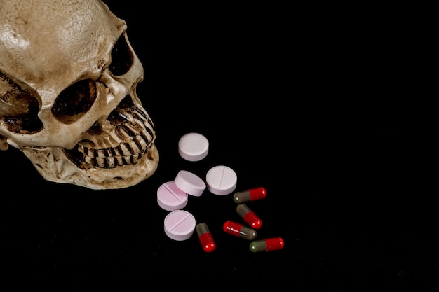 crâne avec la drogue ou la médecine sur le noir