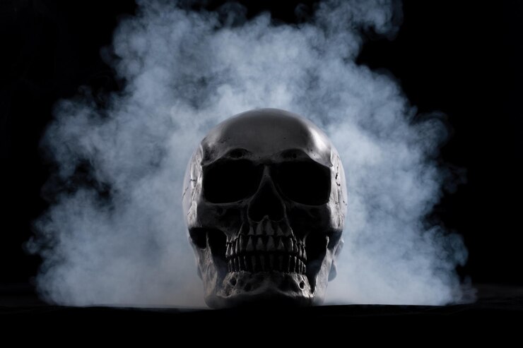 Crâne humain d'Halloween sur une vieille table en bois sur fond noir Forme d'os du crâne pour la tête de mort sur le festival d'halloween qui montre l'horreur de la peur des dents maléfiques et effrayant avec l'espace de copie de fumée de brouillard