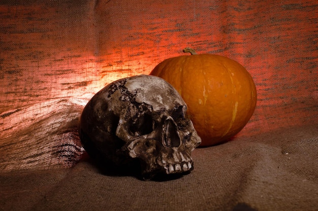 Crâne humain avec lumière rouge sur fond textile marron Concept de décorations d'Halloween