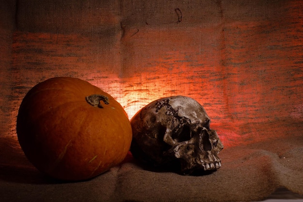 Crâne humain avec lumière rouge sur fond textile marron Concept de décorations d'Halloween