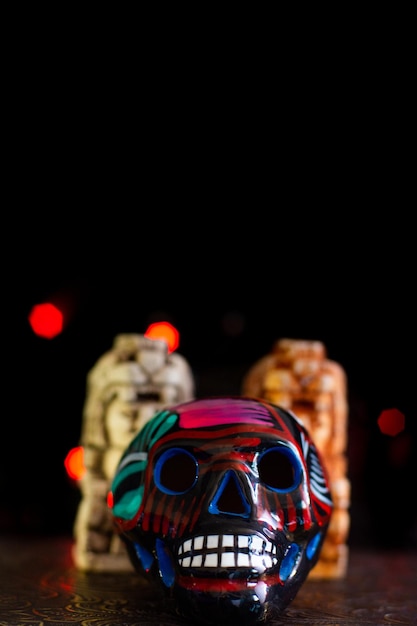 Crâne mexicain dia de muertos en céramique sur fond noir avec des lumières