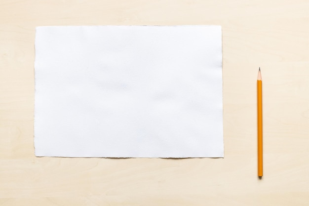 Photo crayon en bois près d'une feuille de papier blanc vierge