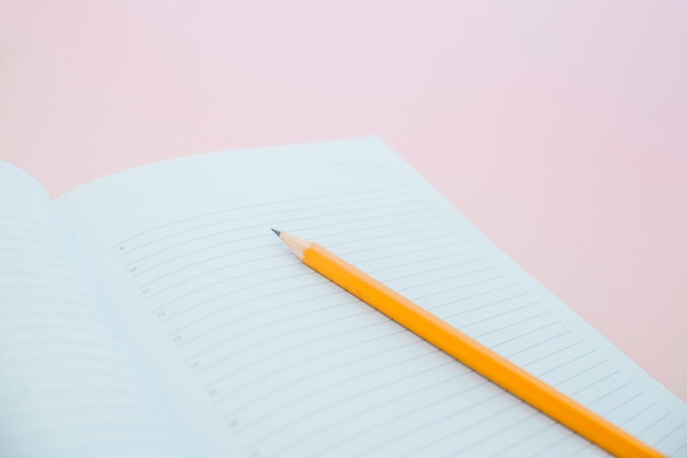 Un crayon sur un cahier dans le linel. Fournitures scolaires.