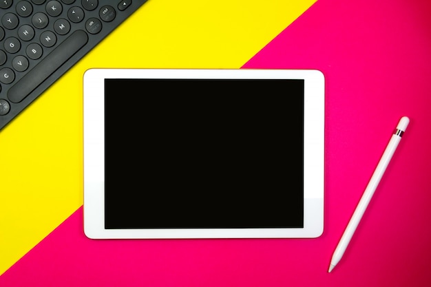 Crayon et clavier sur fond bicolore avec espace de copie jaune et rose pour le texte