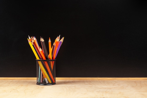 Crayon de couleur dans la tasse sur fond de bois