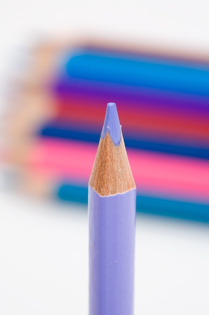 Un crayon violet sur fond de plusieurs couleurs