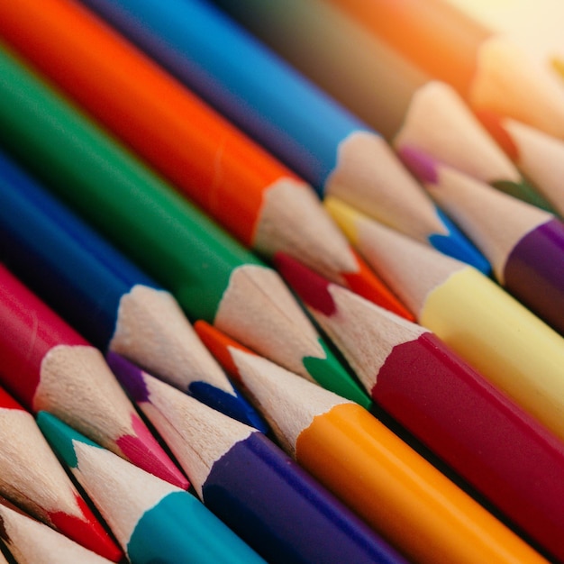 Crayons aiguisés de couleur se trouvent dans une rangée libre Fond abstrait solide de crayons multicolores en bois