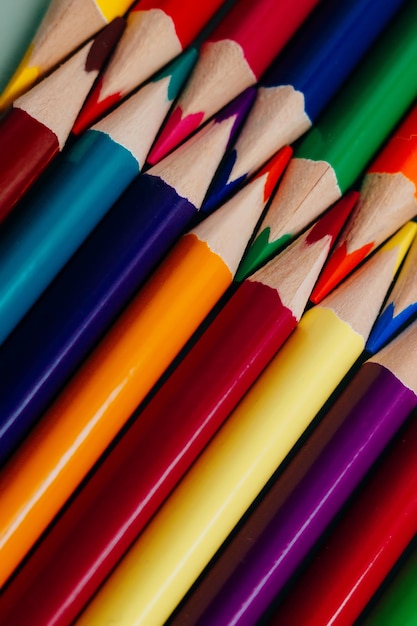 Crayons aiguisés de couleur se trouvent dans une rangée libre Fond abstrait solide de crayons multicolores en bois