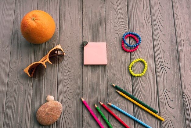 crayons d'artiste pour l'inscription. accessoires crème solaire soins spf. lunettes de soleil bracelets orange