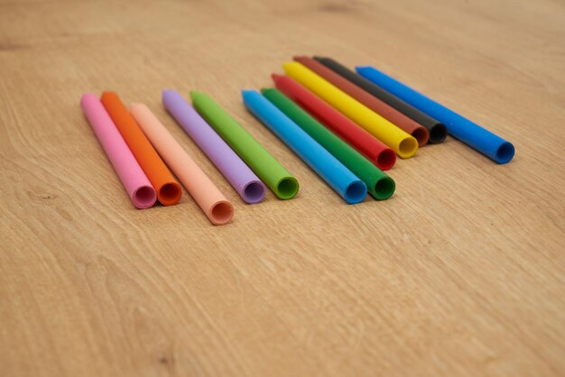 Crayons de cire multicolores pour enfants pour dessiner sur une table en bois.