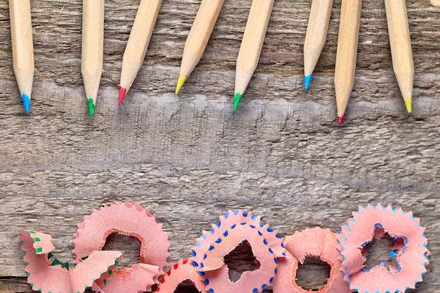 Crayons colorés et copeaux aiguisés sur une table en bois