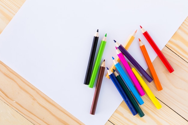 Crayons colorés sur une feuille de papier blanc ligné