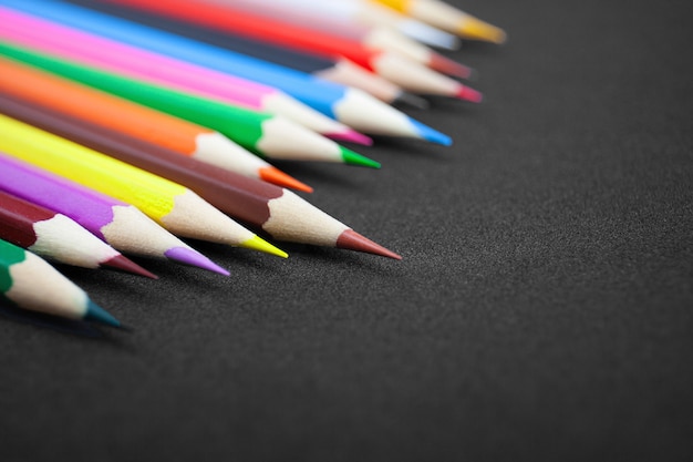 Crayons colorés sur fond noir avec espace de copie.
