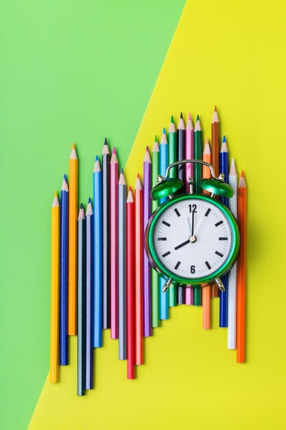 Crayons colorés et réveil Concept de retour à l'école