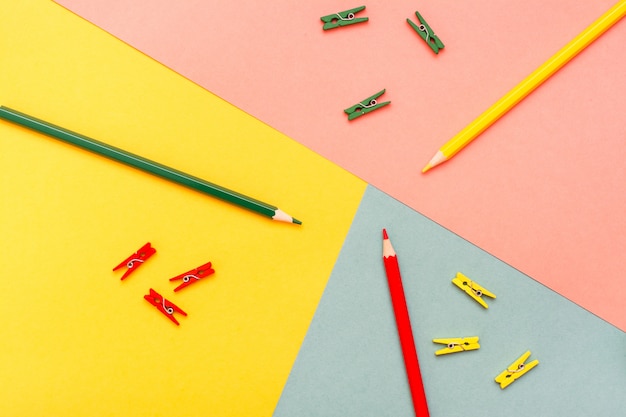 Photo les crayons de couleur et les agrafes sont résumés en jaune, vert et rouge. vue de dessus