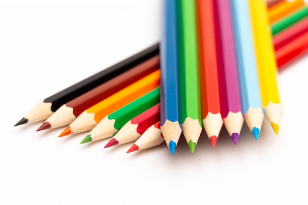 Crayons de couleur en bois de différentes couleurs sur fond blanc