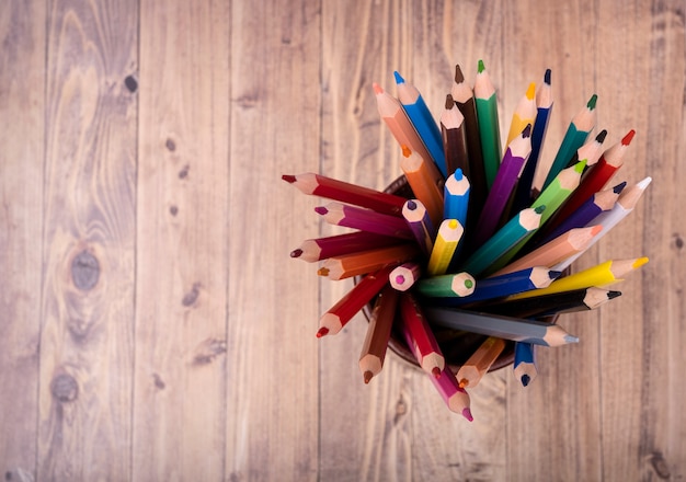 Crayons de couleur en bois, vus d'en haut dans un bécher en cuir marron