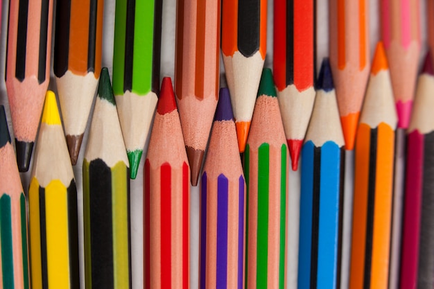 Crayons de couleur disposés en motif imbriqué sur fond blanc