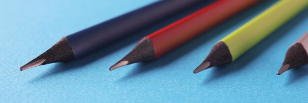 Crayons de couleur disposés par ordre de taille décroissant sur une surface bleue