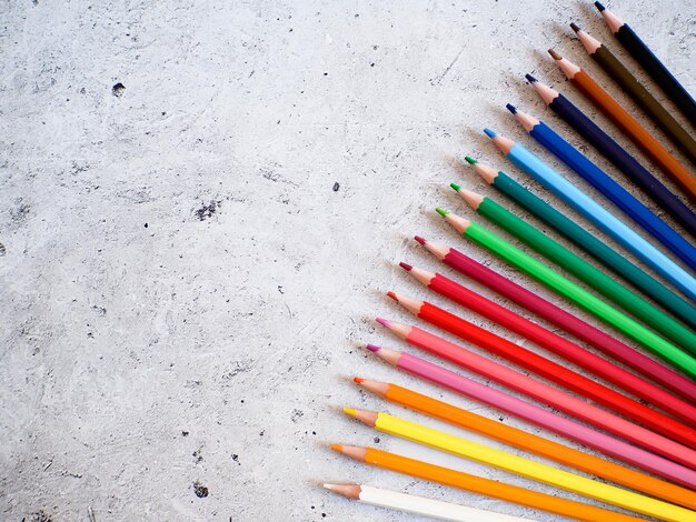 Crayons de couleur sur fond gris Fond d'école