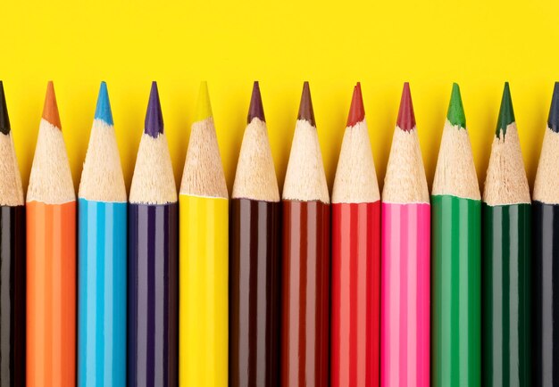 Crayons de couleur sur fond jaune Crayons multicolores