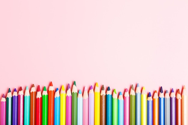 Crayons de couleur sur fond rose Cours de dessin de concept d'école pour les enfants hobby Copier l'espace mise à plat