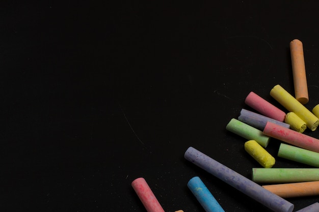 Crayons de couleur sur un fond de tableau noir.