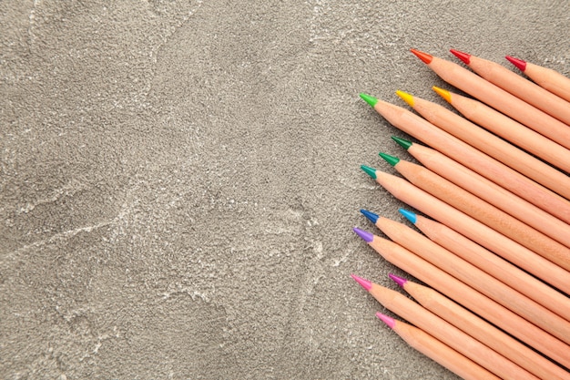 Crayons de couleur sur le mur gris. Vue de dessus.