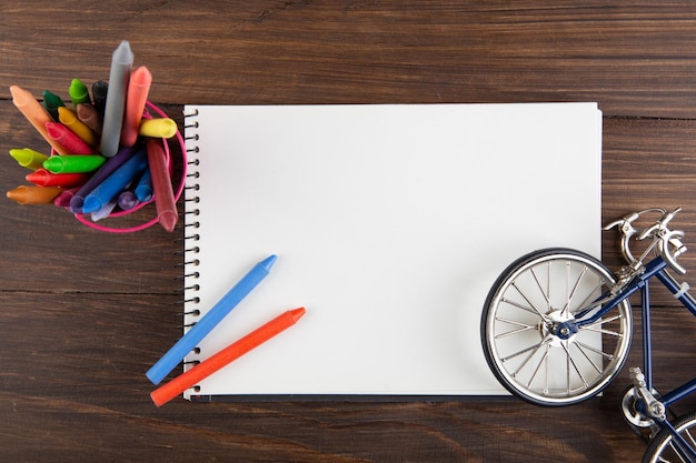 Crayons de couleur et page blanche sur la table en bois