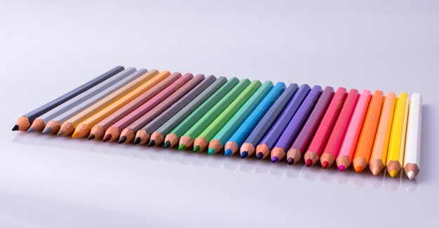 Crayons de couleur placés sur un fond blanc