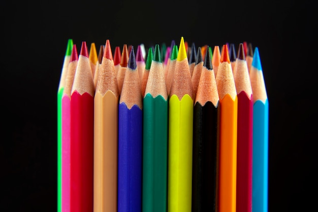 Crayons de couleur pour dessiner sur un fond sombre. Éducation et créativité. Loisirs et art