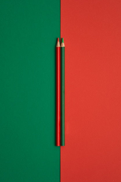 Crayons de couleur rouge et vert isolés sur une table verte et rouge