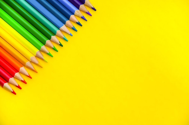 Les crayons de couleur sont isolés sur un fond jaune