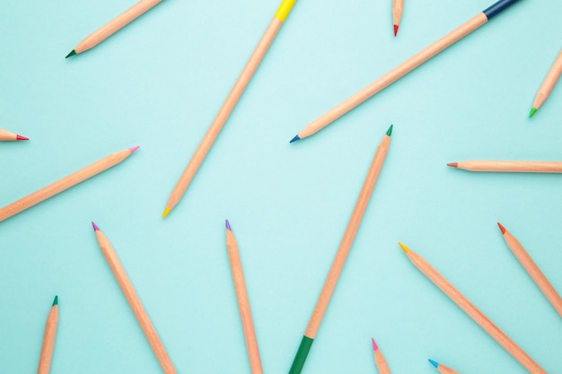 Crayons de couleur sur la surface bleu pastel