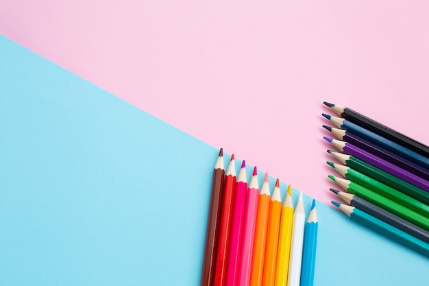 Crayons de couleur vive arc-en-ciel sur fond coloré créatif.