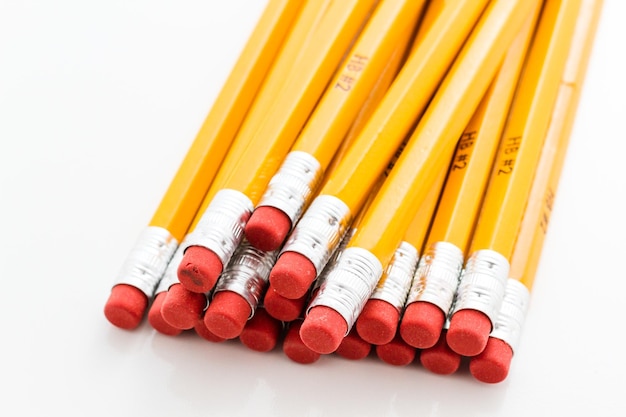 Crayons jaunes classiques avec gomme rouge sur fond blanc.