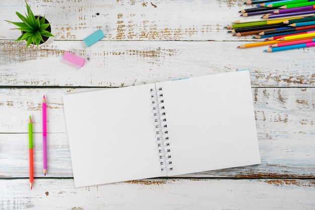 Photo des crayons multicolores et un album pour dessiner sont sur la table.