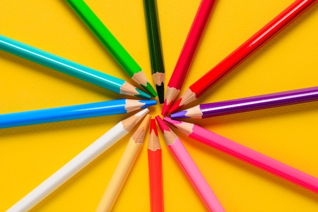 Crayons multicolores sur fond jaune. Crayons de couleur en bois, crayons de couleur pour le dessin.
