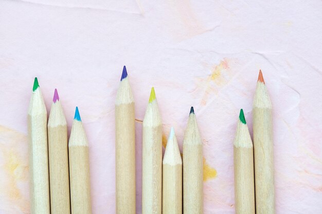 Photo des crayons multicolores sur fond rose